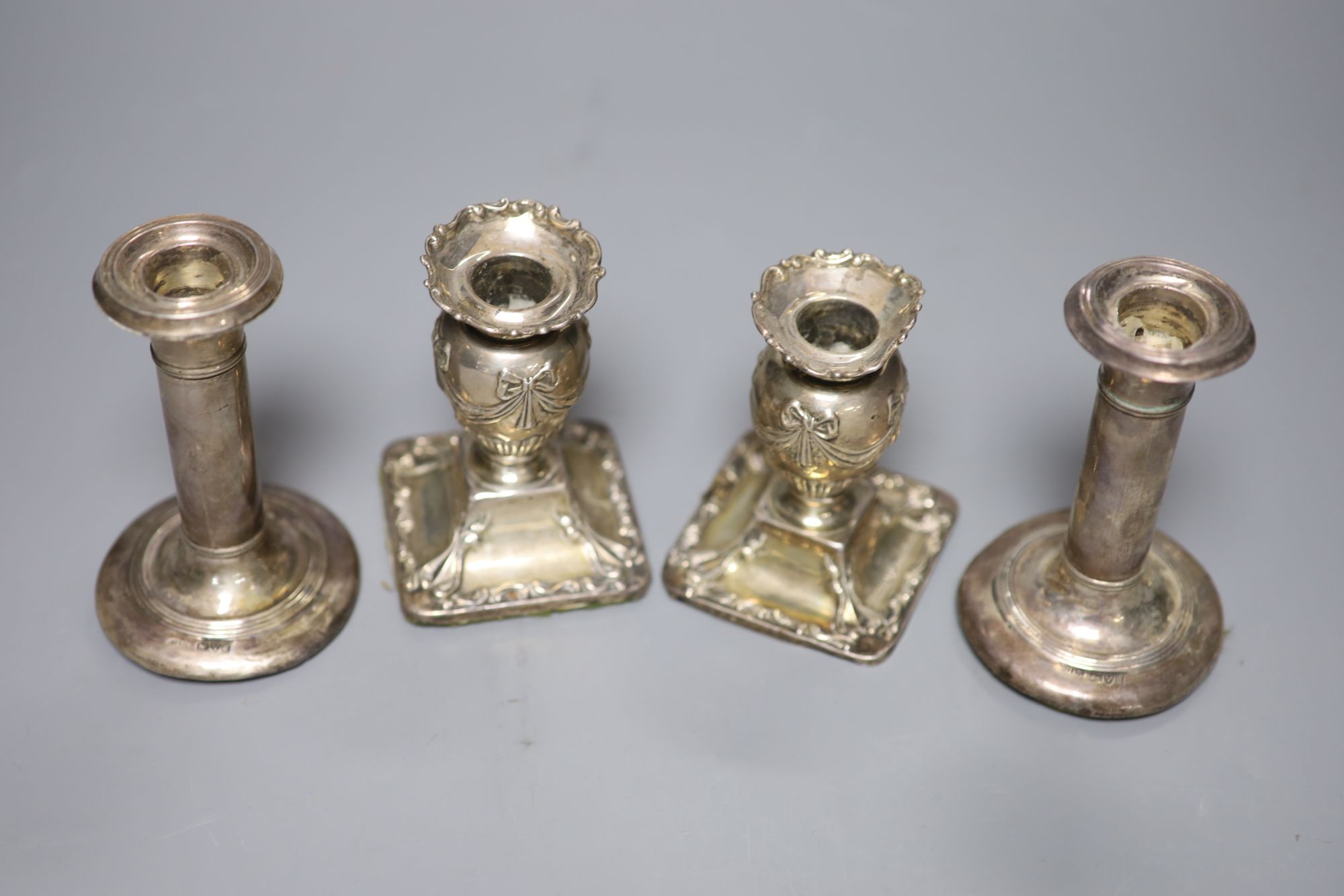 Two pairs of Edwardian silver dwarf candlesticks (a.f.), 11.5cm et infra.